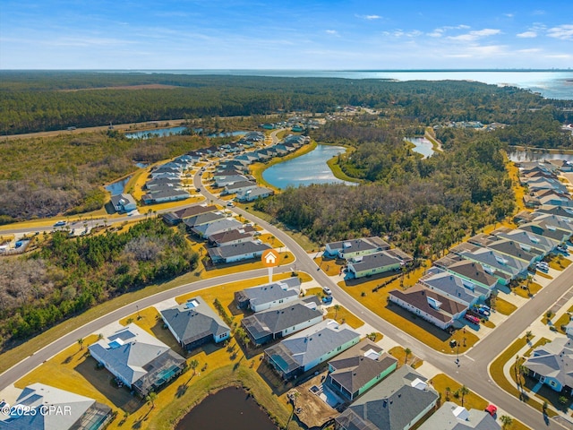 birds eye view of property with a water view, a residential view, and a wooded view