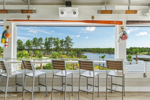 sunroom featuring a water view