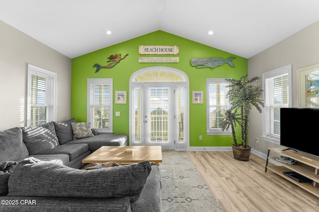 living room with plenty of natural light, light hardwood / wood-style flooring, and lofted ceiling