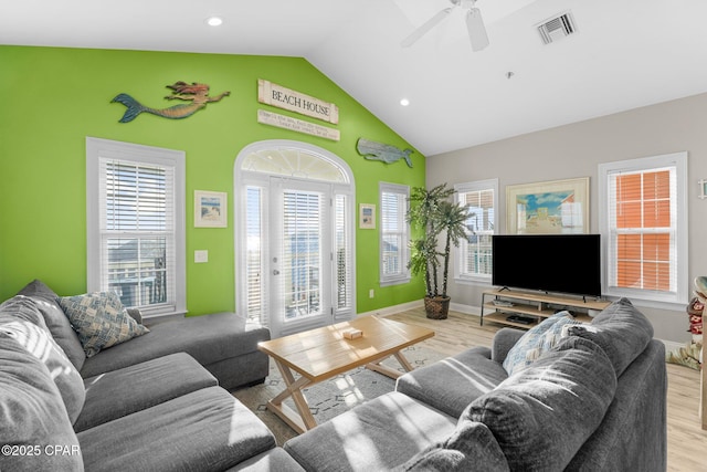 living room featuring ceiling fan, high vaulted ceiling, and light hardwood / wood-style flooring