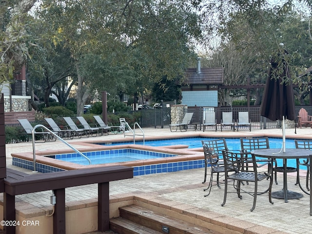 view of swimming pool featuring a community hot tub and a patio