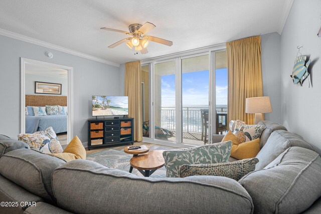 living room with hardwood / wood-style floors, ceiling fan, a wall of windows, and crown molding