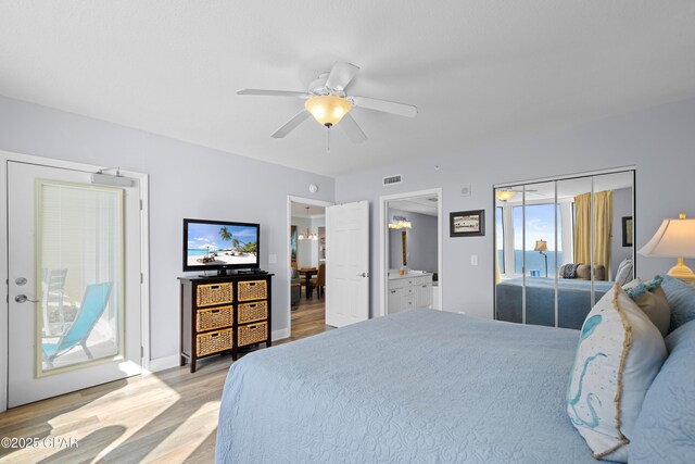 bedroom featuring access to outside, connected bathroom, ceiling fan, and light wood-type flooring