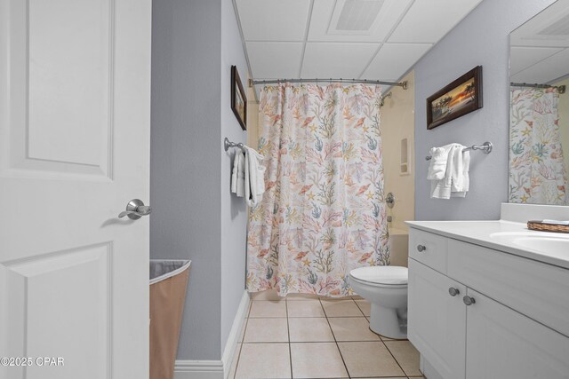 full bathroom with shower / bath combo, a paneled ceiling, tile patterned floors, vanity, and toilet