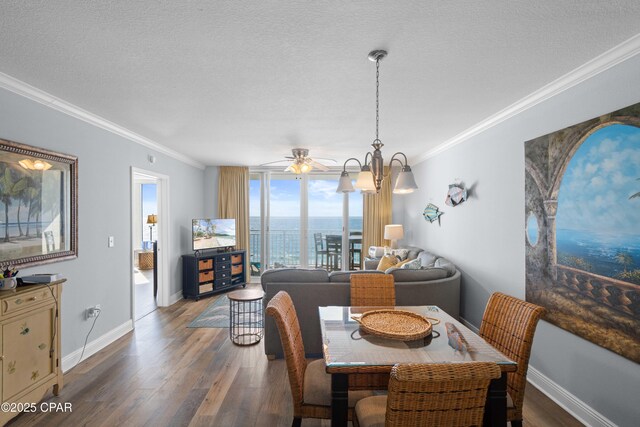 dining area featuring ceiling fan with notable chandelier, dark hardwood / wood-style flooring, a textured ceiling, and crown molding