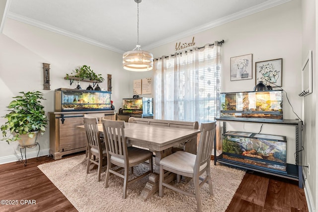 dining room with hardwood / wood-style flooring, crown molding, and a chandelier