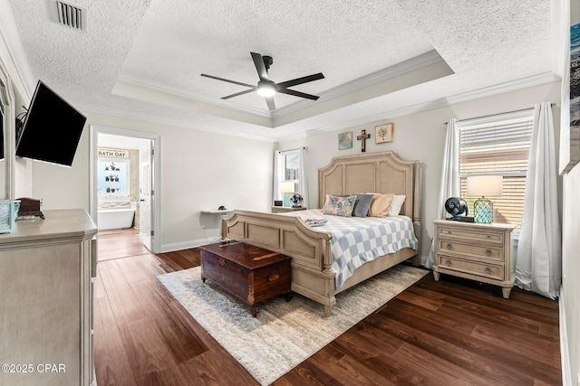 bedroom featuring connected bathroom, a raised ceiling, ceiling fan, and crown molding