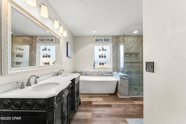 bathroom with vanity, shower with separate bathtub, a textured ceiling, and hardwood / wood-style flooring