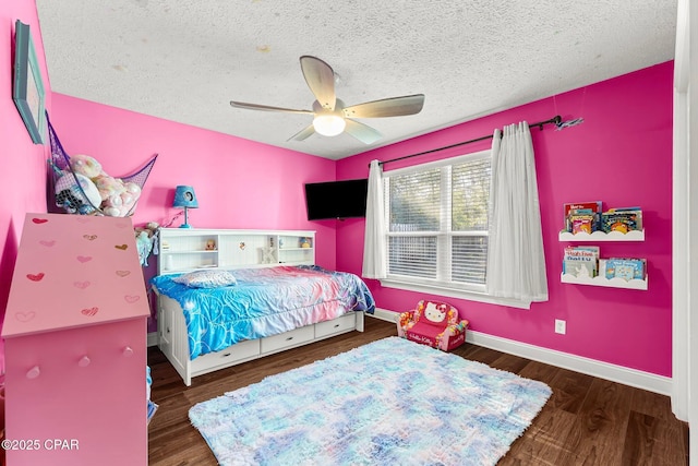 bedroom featuring ceiling fan, dark hardwood / wood-style flooring, and a textured ceiling