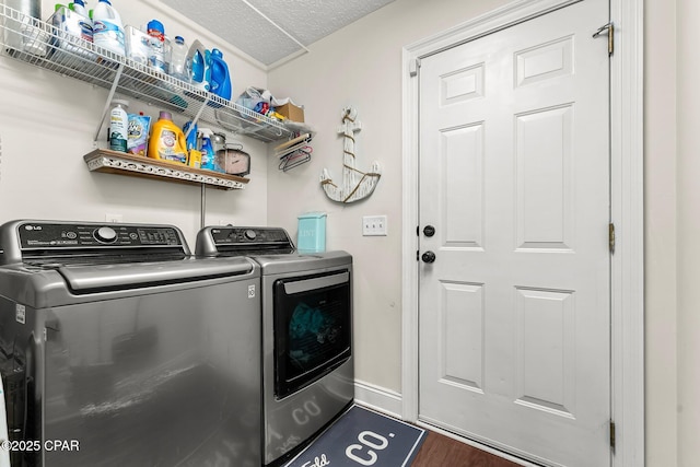 washroom with washer and dryer, dark hardwood / wood-style flooring, and a textured ceiling