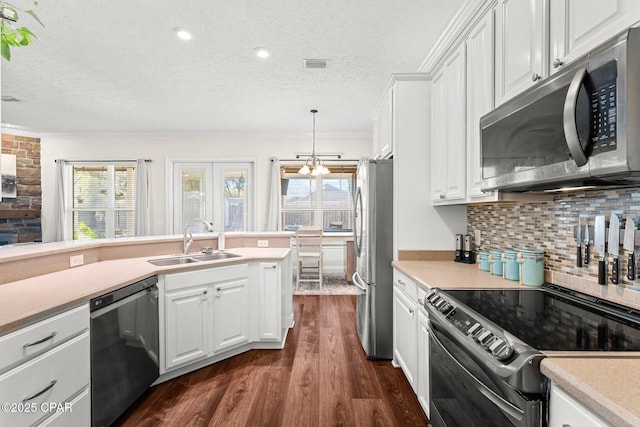 kitchen featuring hanging light fixtures, sink, white cabinets, and black appliances