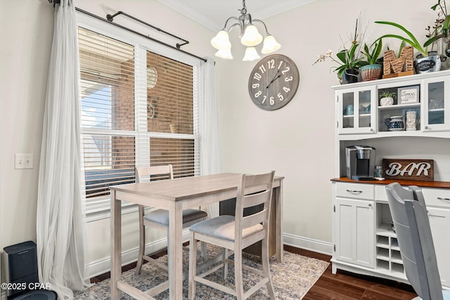 dining space featuring crown molding, dark hardwood / wood-style flooring, and a notable chandelier