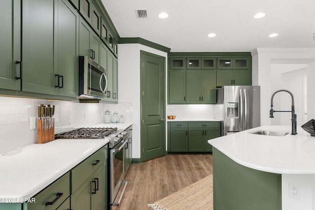 kitchen with green cabinets, appliances with stainless steel finishes, and sink