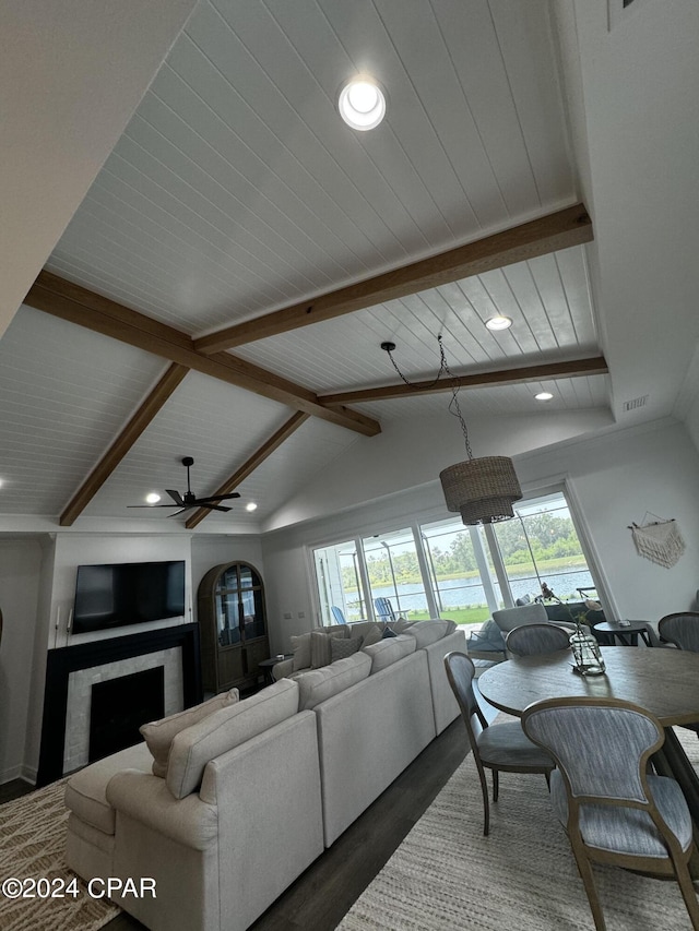 living room with ceiling fan, dark hardwood / wood-style floors, and vaulted ceiling with beams