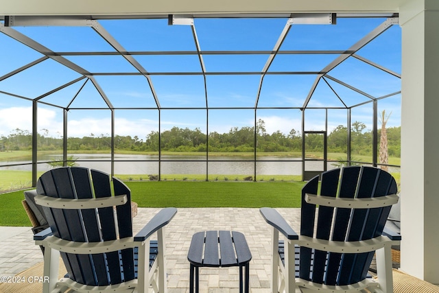 view of patio with a water view and glass enclosure