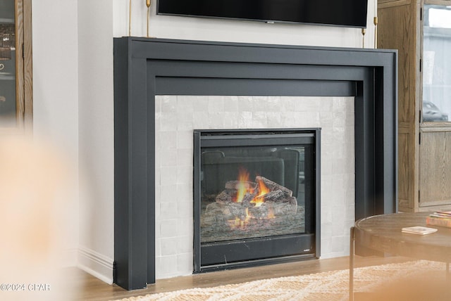 room details with a tile fireplace and hardwood / wood-style floors