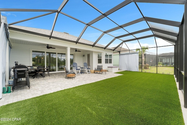 rear view of property with a fire pit, ceiling fan, glass enclosure, and a patio area