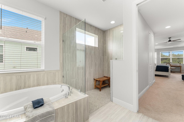 bathroom with ceiling fan and plus walk in shower