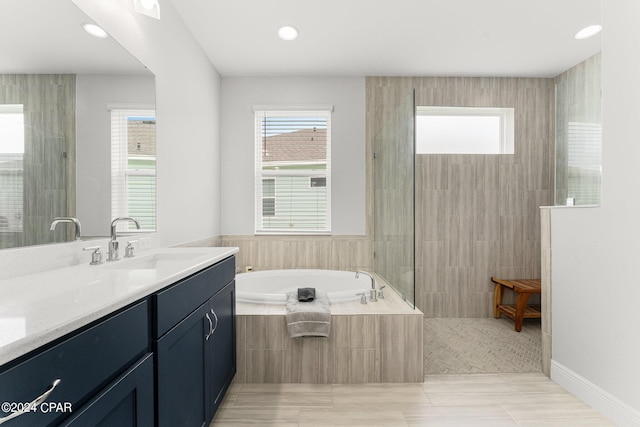 bathroom with tile patterned flooring, separate shower and tub, and vanity