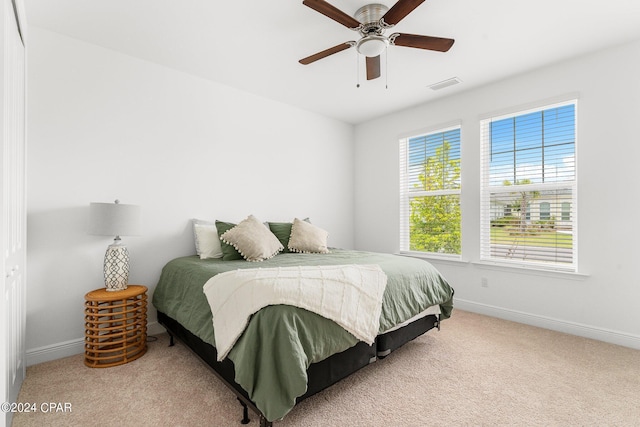 carpeted bedroom with ceiling fan and multiple windows