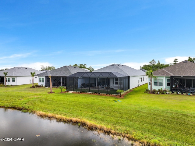 back of property featuring a lawn, glass enclosure, and a water view