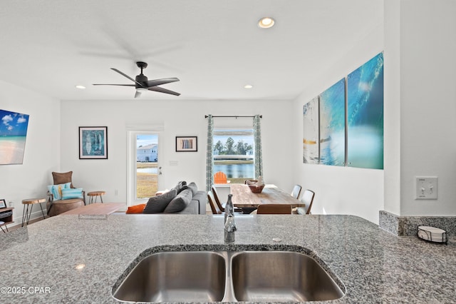 kitchen with stone countertops, sink, and ceiling fan