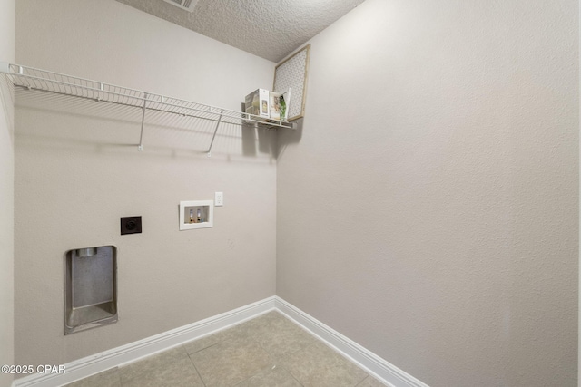 laundry room with electric dryer hookup, washer hookup, tile patterned floors, and a textured ceiling