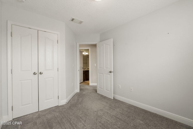 unfurnished bedroom with a closet, carpet, and a textured ceiling