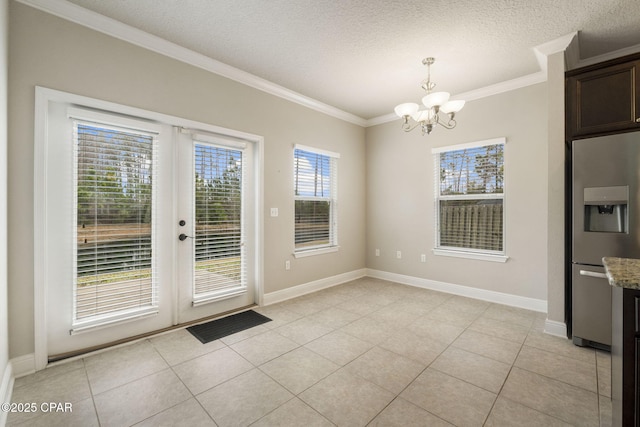 unfurnished dining area with ornamental molding, light tile patterned floors, a textured ceiling, and french doors