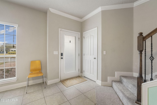 entrance foyer with light tile patterned flooring, a textured ceiling, and crown molding