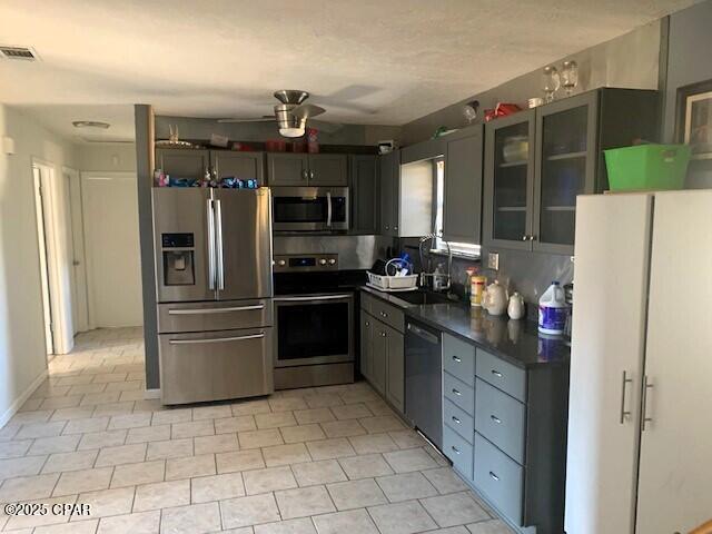 kitchen featuring gray cabinets, appliances with stainless steel finishes, light tile patterned floors, ceiling fan, and sink