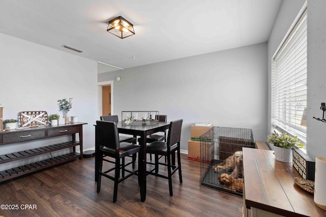 dining room with dark wood-style floors, visible vents, and baseboards