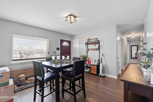 dining space featuring baseboards and dark wood-style flooring