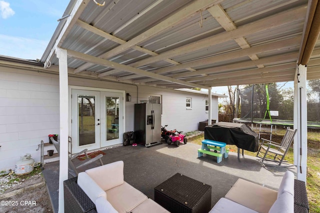 view of patio featuring a trampoline, an outdoor hangout area, area for grilling, and french doors