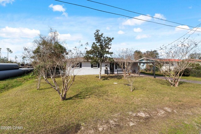 ranch-style home featuring a carport, aphalt driveway, and a front yard