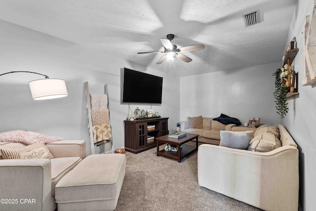 carpeted living area with a ceiling fan, visible vents, and a textured ceiling