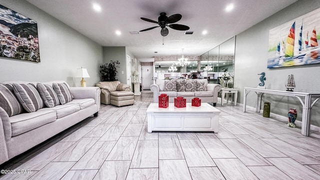 living room with ceiling fan with notable chandelier