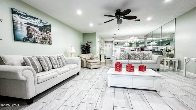 living room featuring ceiling fan with notable chandelier