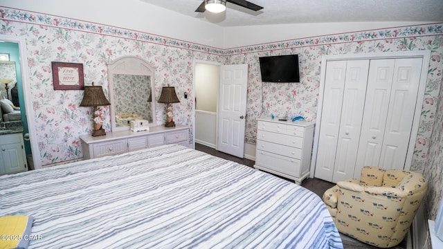 bedroom with ensuite bath, ceiling fan, a closet, and lofted ceiling