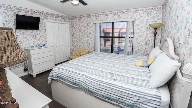 bedroom featuring ceiling fan, a closet, dark wood-type flooring, and lofted ceiling