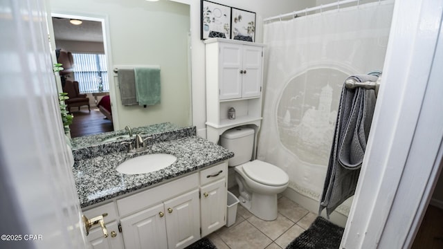 bathroom with tile patterned flooring, vanity, toilet, and a shower with curtain