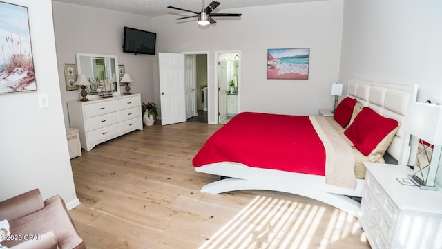 bedroom featuring lofted ceiling, ensuite bathroom, ceiling fan, a textured ceiling, and light hardwood / wood-style floors