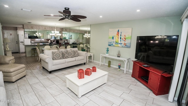 living room with ceiling fan with notable chandelier