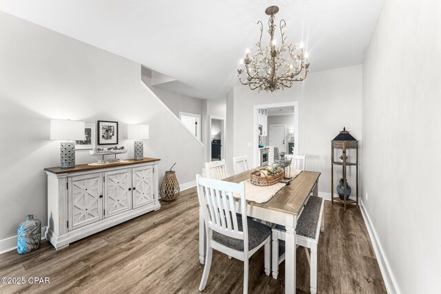 dining room featuring dark wood-type flooring and an inviting chandelier