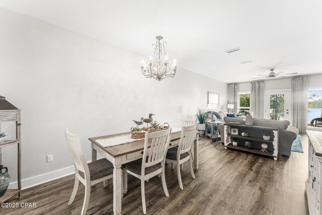 dining space featuring dark hardwood / wood-style flooring and ceiling fan with notable chandelier