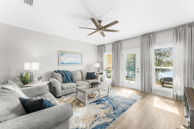 living room with light wood-type flooring and ceiling fan