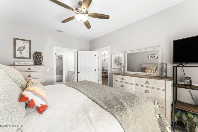 bedroom with a spacious closet, ceiling fan, and ensuite bathroom