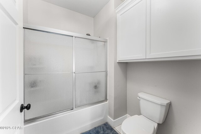 bathroom with toilet and enclosed tub / shower combo