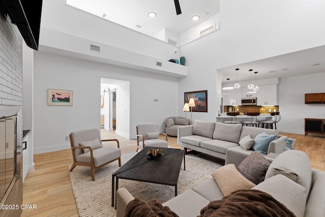 living room with light hardwood / wood-style flooring and a high ceiling