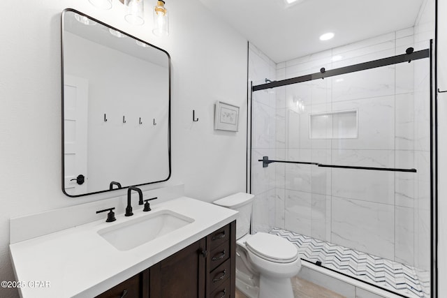 bathroom featuring vanity, toilet, and a shower with door